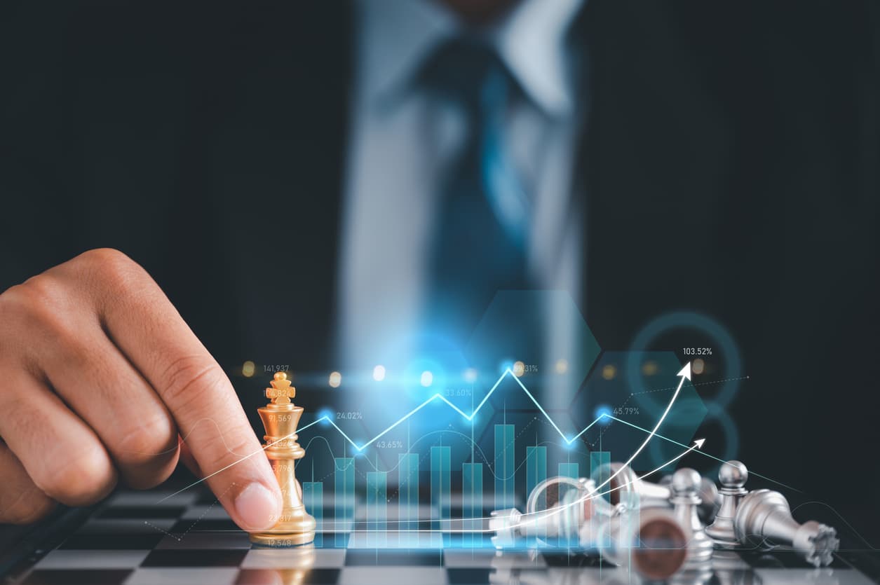 Businessman in black suite sitting player chess.